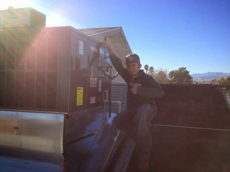 HVAC technician performing Air Duct Cleaning on a rooftop unit in Papillion